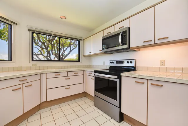 a kitchen with stainless steel appliances granite countertop white cabinets a sink and a stove