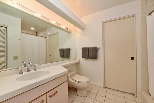 a bathroom with a toilet a sink a mirror and shower