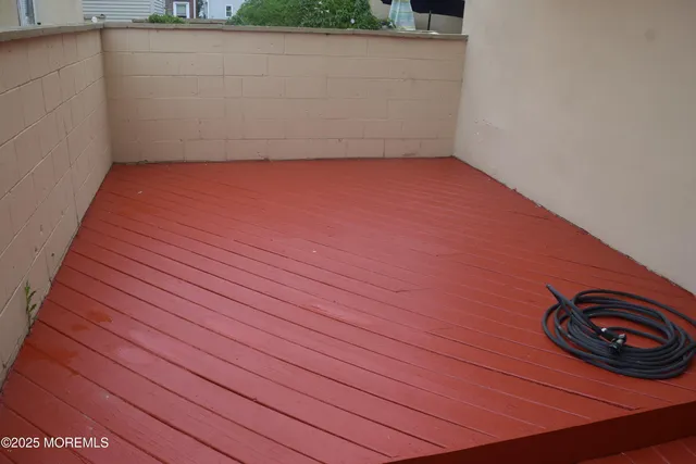 a view of an empty room with a sink and wooden floor