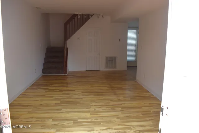 a view of room with stairs and wooden floor
