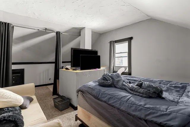 a bedroom with a bed and a television