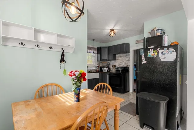 a kitchen with stainless steel appliances granite countertop a refrigerator a stove a sink dishwasher and a dining table with wooden floor