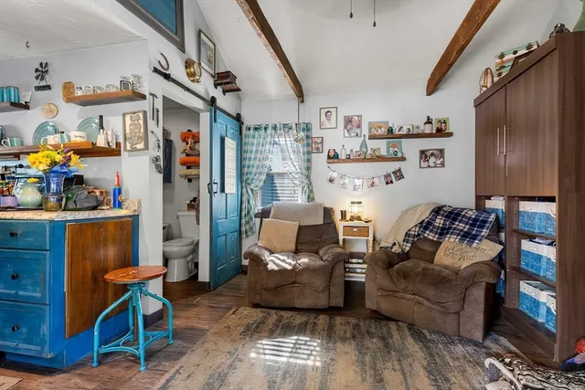 a room with lots of white furniture and a chandelier