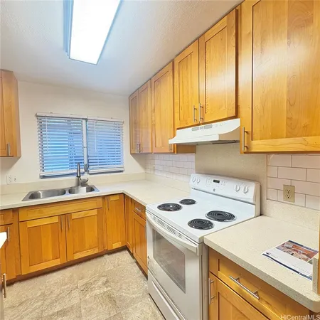 a kitchen with a sink a stove and cabinets