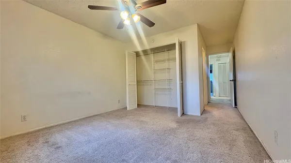 an empty room with fan and entrance