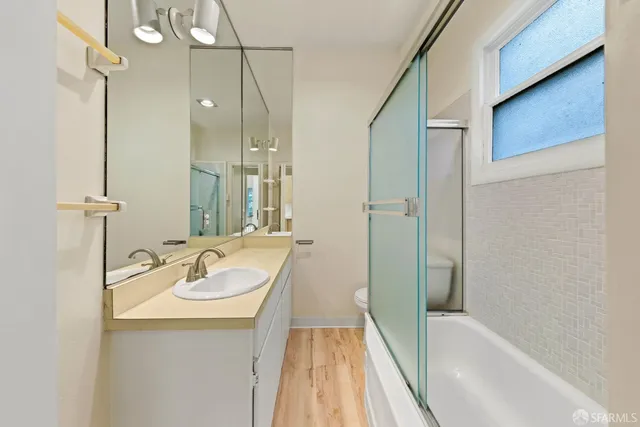 a kitchen with stainless steel appliances a refrigerator sink and wooden floor