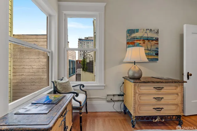 a view of a hallway with wooden floor and windows