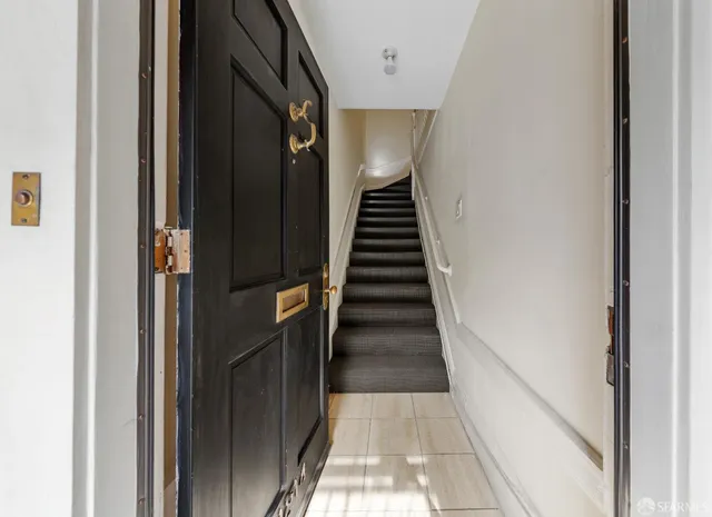 a view of a hallway with wooden floor and staircase