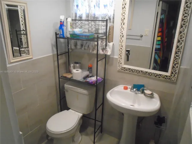 a bedroom with a bed a flat screen tv and dresser