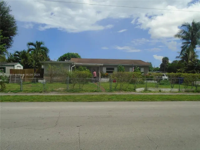 a view of a house with a big yard and a large trees