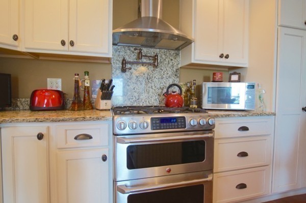 49 Faywood Avenue Boston, MA 02128 - Photo 4 of 30 a kitchen with stainless steel appliances granite countertop white cabinets and a stove