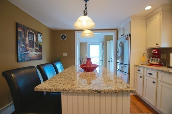 49 Faywood Avenue Boston, MA 02128 - Photo 6 of 30 a kitchen with stainless steel appliances kitchen island granite countertop a table chairs in it and wooden floors