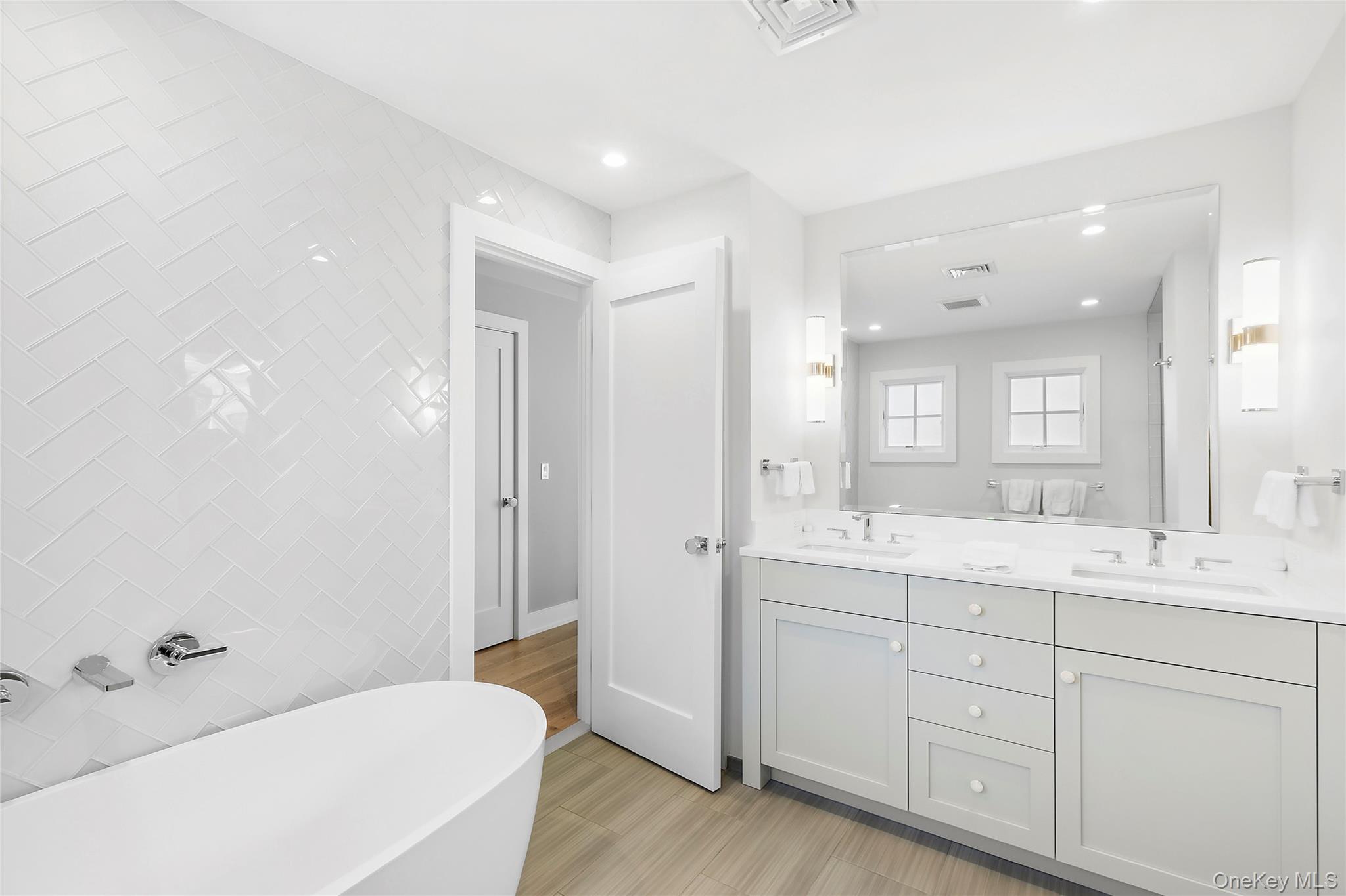 8 Shore Road Remsenburg, NY 11960 - Photo 14 of 21 a spacious bathroom with a double vanity sink a mirror and a bathtub