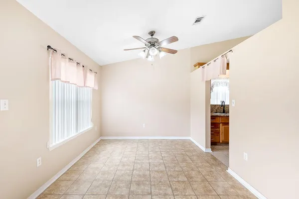 a view of an empty room with closet and a window