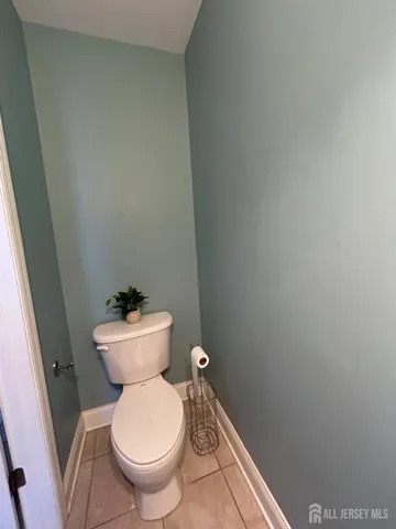a white toilet sitting next to a white cabinet