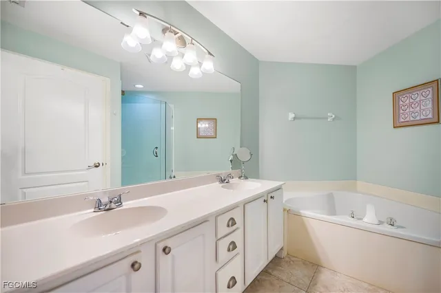 a bathroom with a bathtub a double vanity sink and a mirror