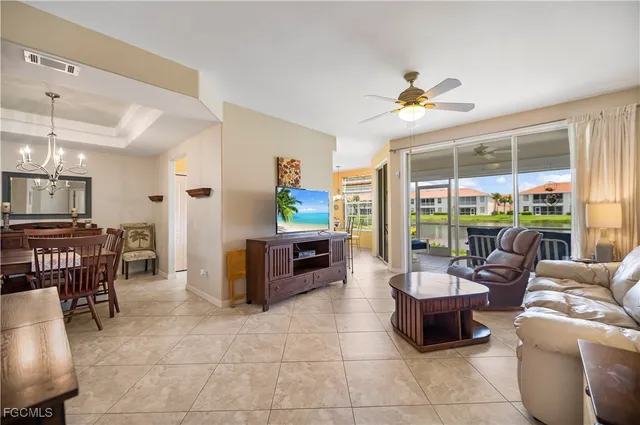 a living room with furniture a flat screen tv and a large window