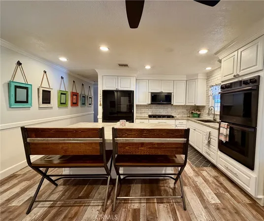 a kitchen with stainless steel appliances kitchen island granite countertop a refrigerator and microwave