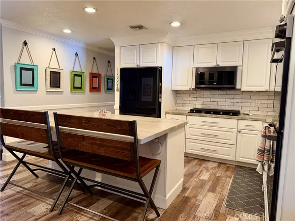 a kitchen with stainless steel appliances kitchen island granite countertop a stove and a sink