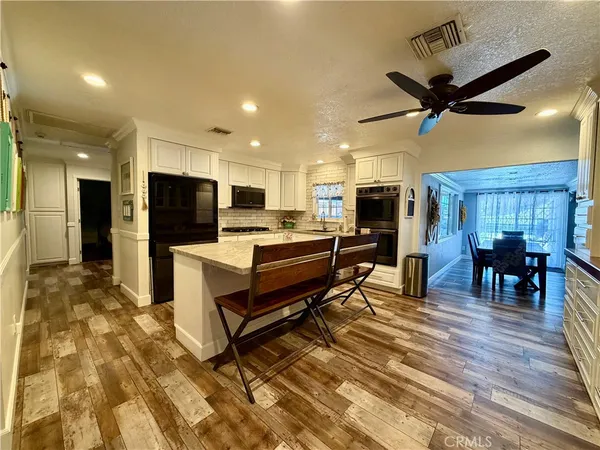 a living room with stainless steel appliances kitchen island furniture and a view of kitchen