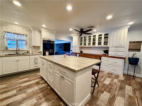 a kitchen with stainless steel appliances kitchen island granite countertop a sink and cabinets