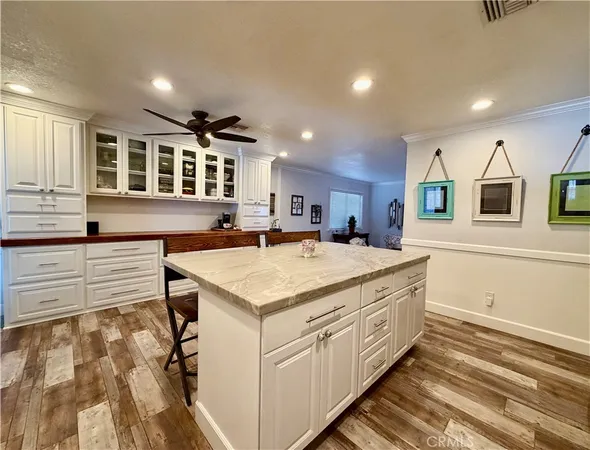 a kitchen that has a lot of cabinets and wooden floor