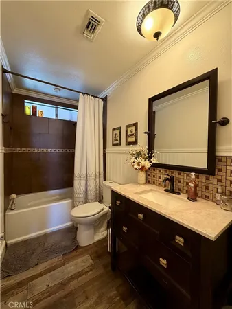 a bathroom with a double vanity sink toilet mirror and bathtub
