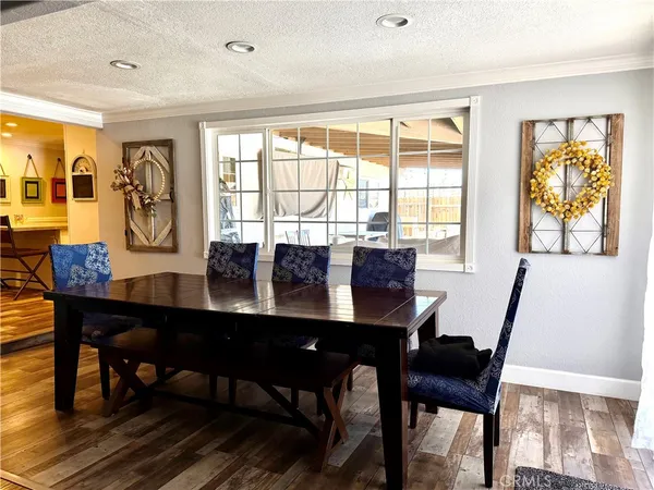 a dining room with wooden floor and large windows
