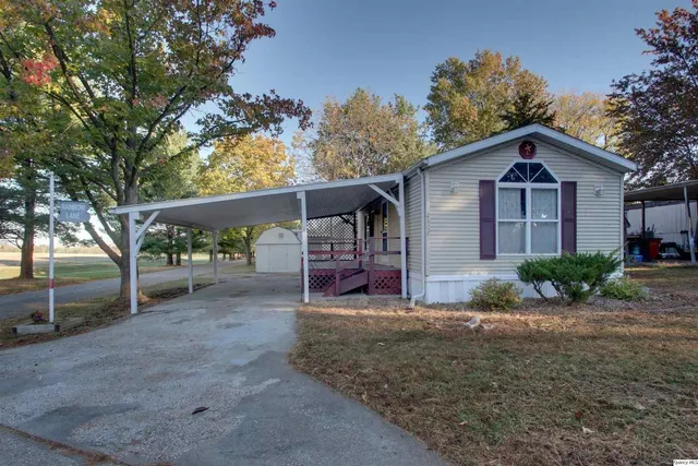a view of a house with a yard and large tree