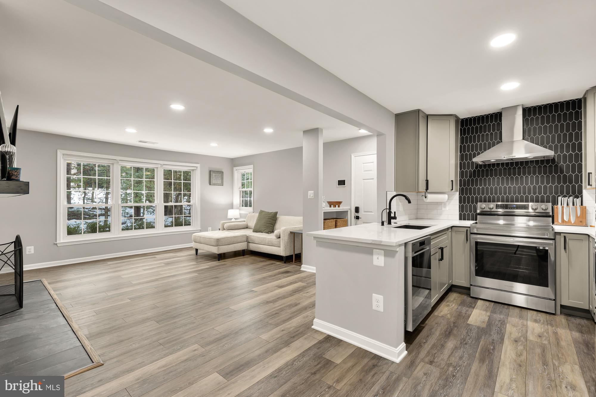 a kitchen with stainless steel appliances granite countertop a stove and a large window