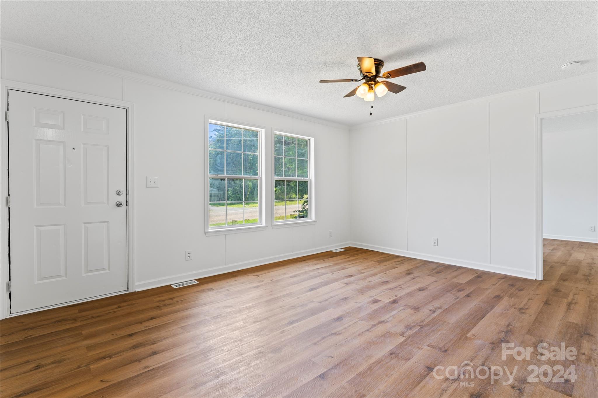 669 Ross Road Lincolnton, NC 28092 - Photo 8 of 30 an empty room with wooden floor chandelier fan and windows