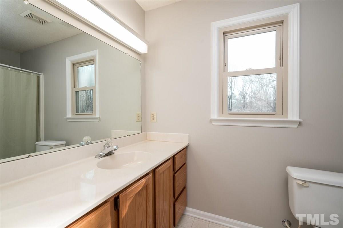 8720 Ball Road Bahama, NC 27503 - Photo 22 of 30 a bathroom with a sink a toilet and a window