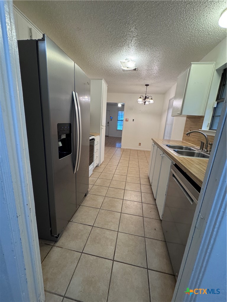 1301 North 10th Street Temple, TX 76501 - Photo 9 of 25 a kitchen with stainless steel appliances granite countertop a refrigerator and a stove