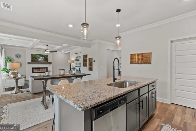 a kitchen with granite countertop a sink a counter top space and living room view