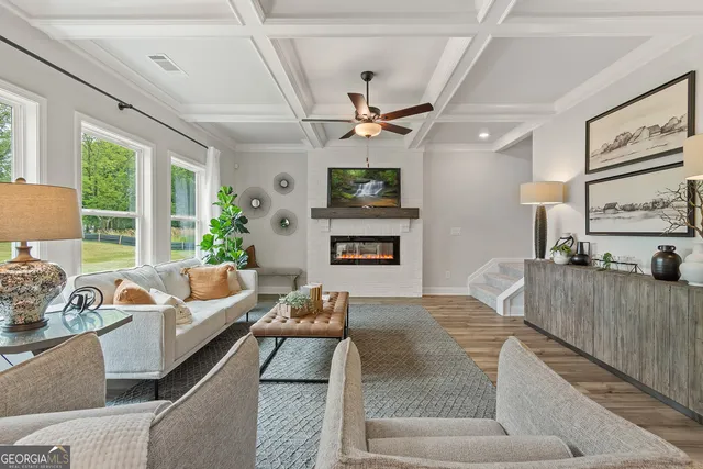 a living room with furniture a flat screen tv and a fireplace