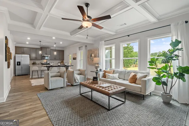 a living room with furniture and kitchen view