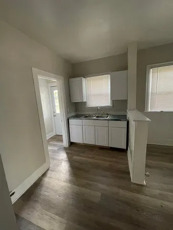 a kitchen with granite countertop a sink and cabinets