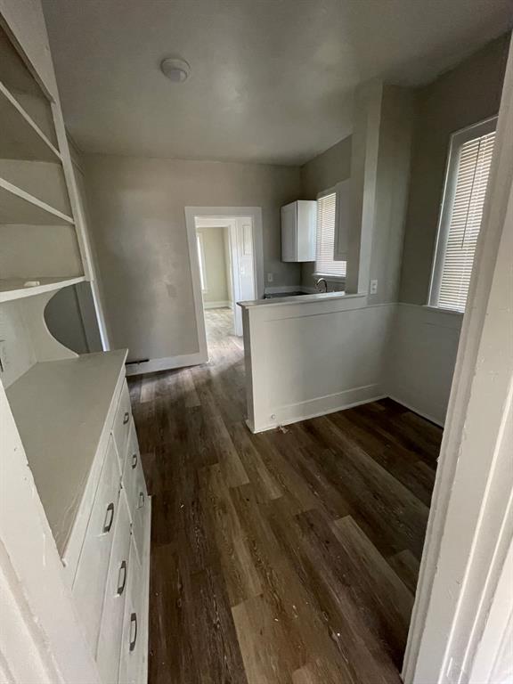 516 South Nueces Street Coleman, TX 76834 - Photo 17 of 20 a view of kitchen and empty room with wooden floor