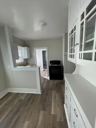 a kitchen with a wooden floor and a view of kitchen