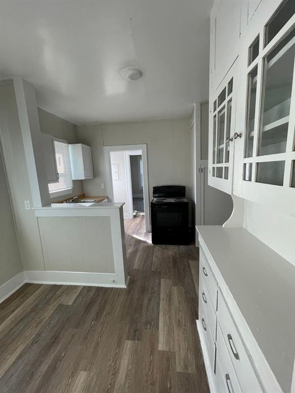 516 South Nueces Street Coleman, TX 76834 - Photo 10 of 20 a kitchen with a wooden floor and a view of kitchen