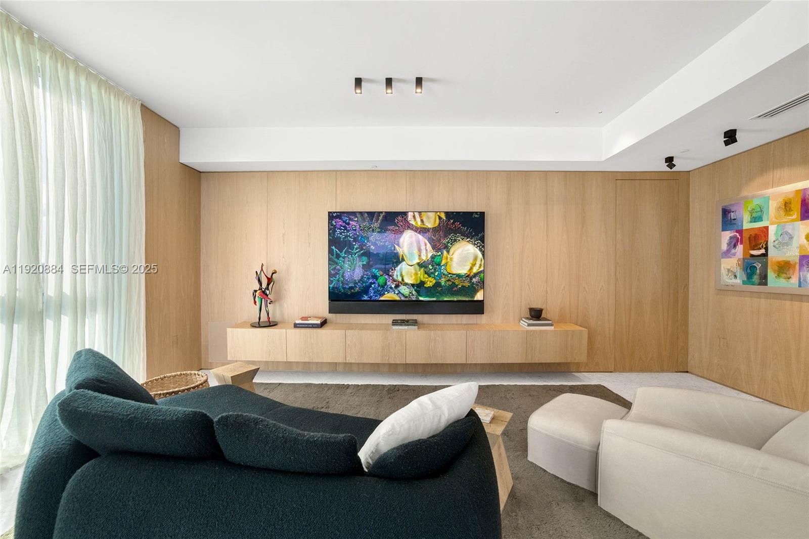 5775 Collins Avenue, Unit 1501 Miami Beach, FL 33140 - Photo 24 of 77 a living room with furniture and a flat screen tv