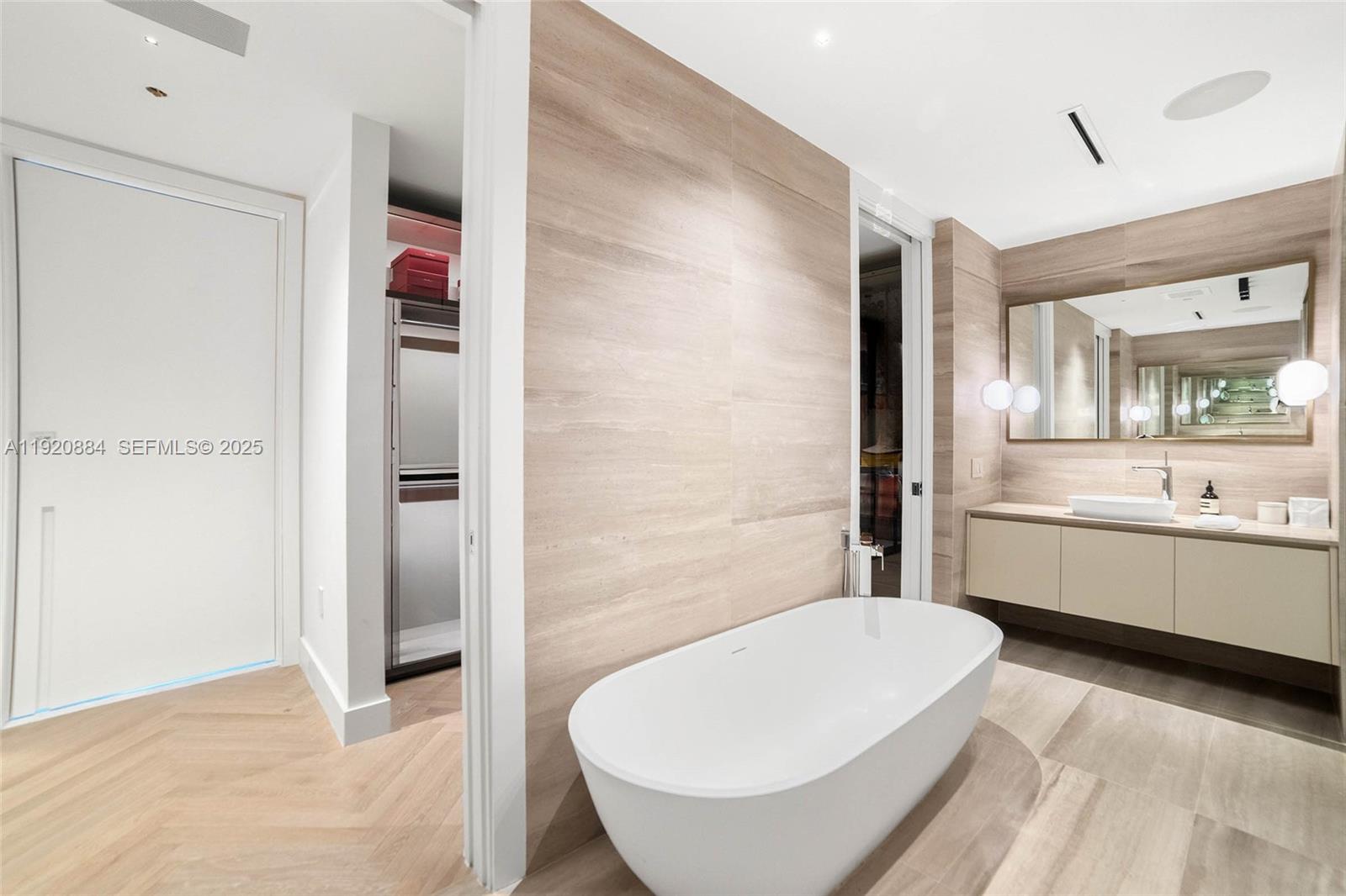 5775 Collins Avenue, Unit 1501 Miami Beach, FL 33140 - Photo 31 of 77 a bathroom with a tub shower sink and mirror