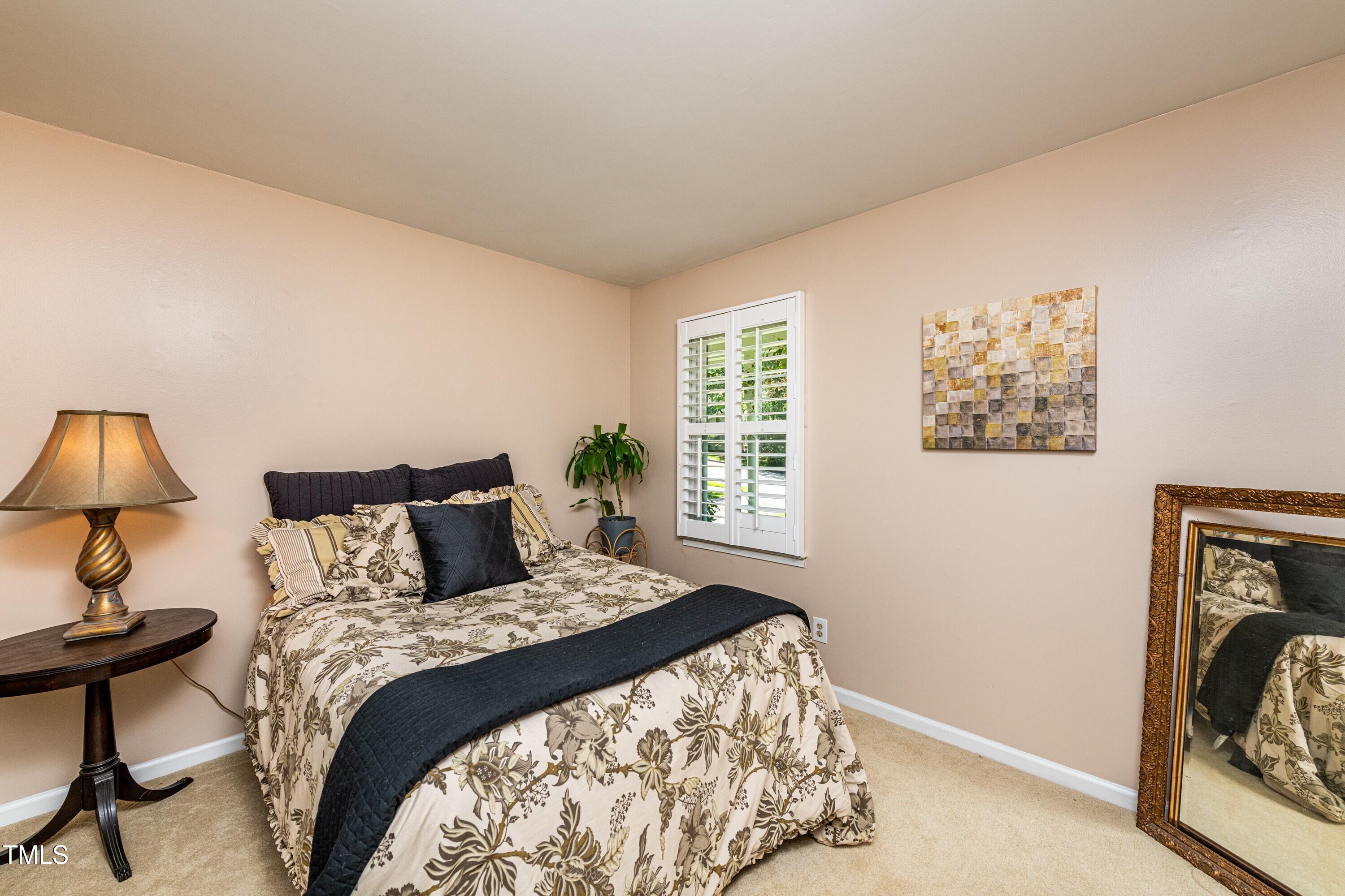 1008 Mockingbird Drive Raleigh, NC 27615 - Photo 21 of 32 a bedroom with a bed and a lamp next to a window