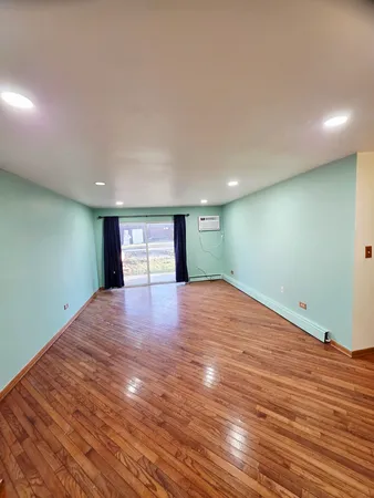 a view of a room with wooden floor and chairs