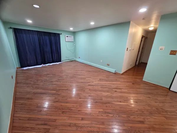 a view of an empty room with wooden floor
