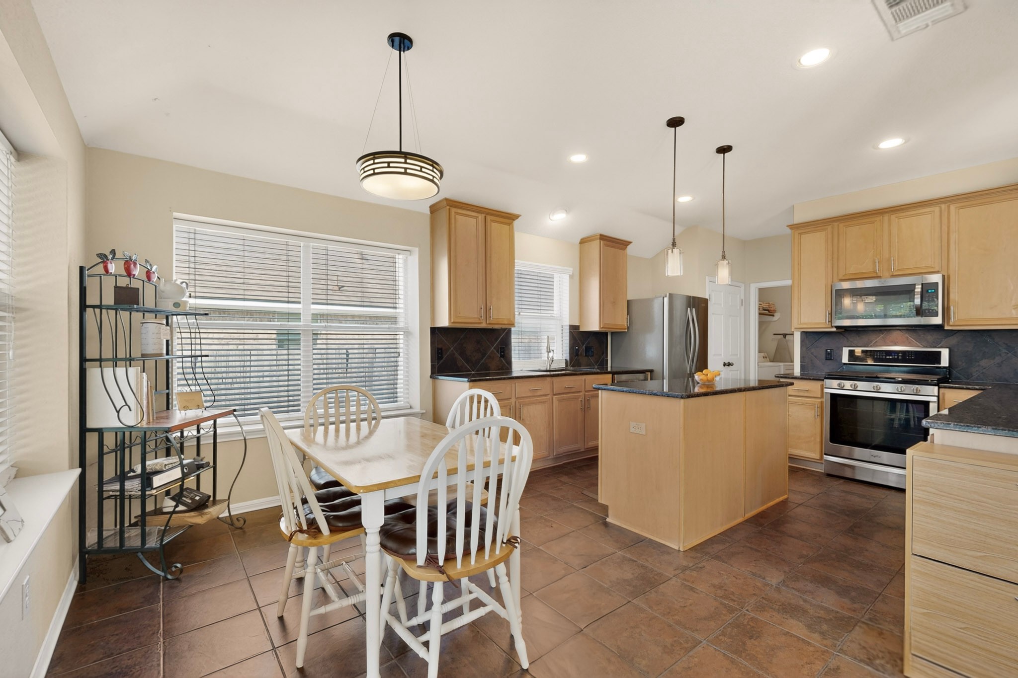 905 Victoria Ridge Drive Pflugerville, TX 78660 - Photo 12 of 32 A well-lit kitchen and breakfast area features granite countertops and stainless steel appliances.