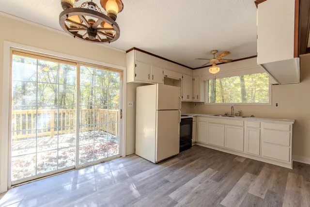 a kitchen with a refrigerator and a white wooden cabinets