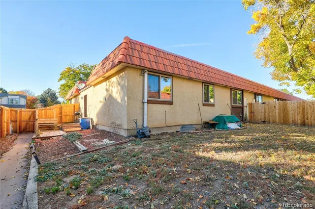 a backyard of a house with barbeque oven table and chairs