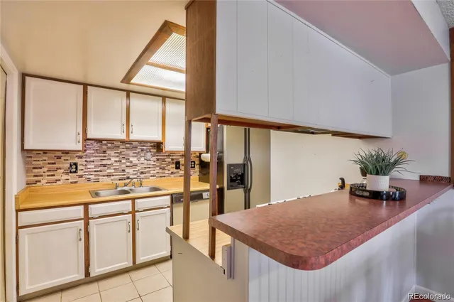 a kitchen with stainless steel appliances kitchen island granite countertop a refrigerator and cabinets
