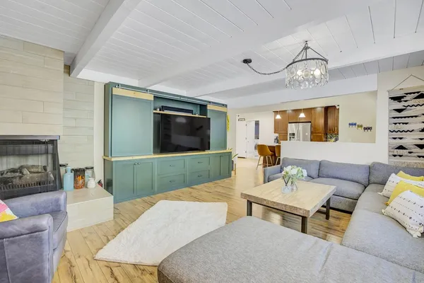 a kitchen with kitchen island a refrigerator a stove a sink a dining table and chairs